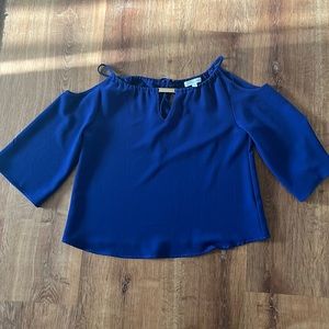 Loose fitted, cut outs at the shoulders, gold detail at the top